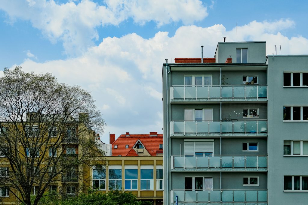 City apartment buildings with diverse architectural styles under a clear blue sky.